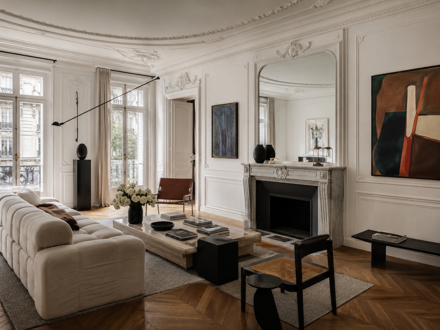 Living room with a cream modular sofa, a limestone fireplace beneath an arched mirror, a large abstract painting and oak parquet